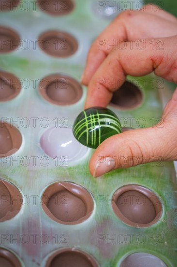 A green, artfully decorated ball is removed from a mold, Weihnachtsbacken, Haselstaller Hof, Wildberg, Calw district, Germany