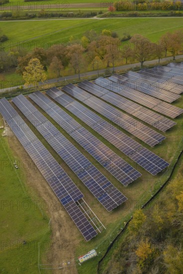 Close view of solar panels in a field with adjacent trees, Bau PV Freifaechenanlage, Weil der Stadt, Germany