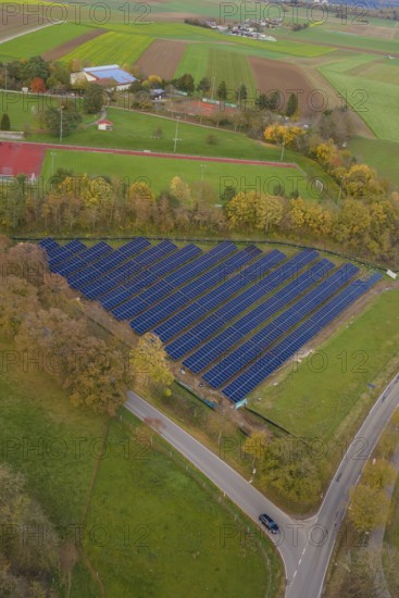 Solar systems embedded in fields and trees shown from the air during autumn, Bau PV Freifaechenanlage, Weil der Stadt, Germany
