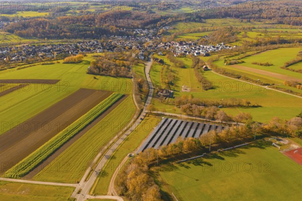 Autumn landscape with fields, forests and a small village viewed from the air, construction PV Freifaechenanlage, Weil der Stadt, Germany