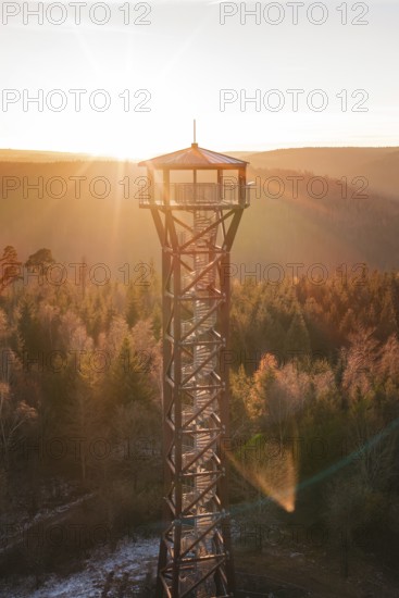 A tower glows in the morning light above the colorful autumn forest, Hohe Warte observation tower, Hohenwart, Pforzheim, Germany