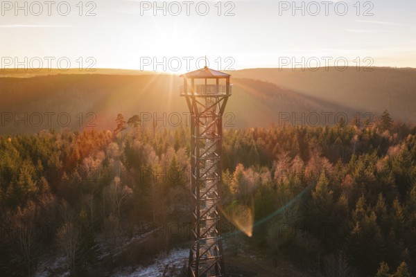 An isolated observation tower overlooks an autumnal forest in first light, Hohe Warte observation tower, Hohenwart, Pforzheim, Germany