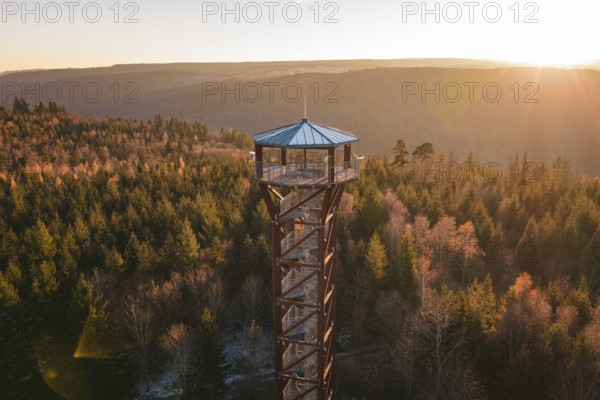 An observation tower rises above an autumnal forest under a sunset, Hohe Warte observation tower, Hohenwart, Pforzheim, Germany