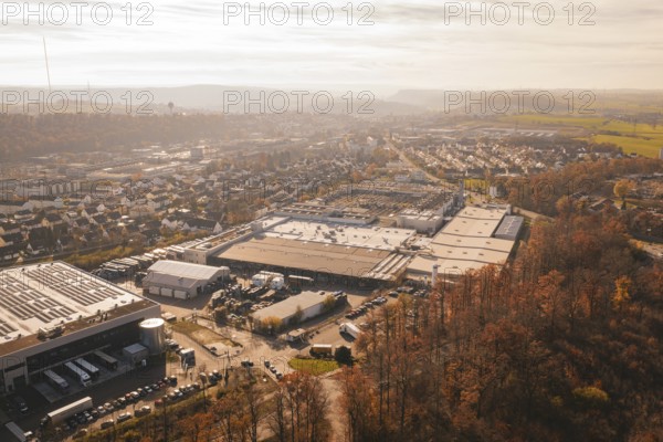 Industrial complex and urban settlements surrounded by autumn vegetation, MÃ¼hlacker, Enzkreis, Germany
