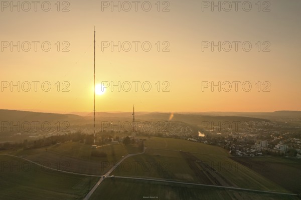 A sunset over countryside and fields with a distinctive transmission tower in the foreground, MÃ¼hlacker, Enzkreis, Germany
