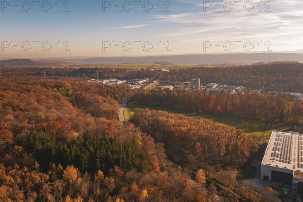 Road through autumnal forest with a wide view of landscape and buildings, MÃ¼hlacker, Enzkreis, Germany