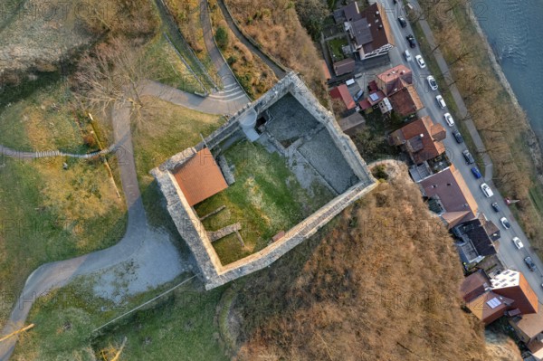 Aerial view of a castle ruins with adjacent streets and houses, surrounded by autumn light, MÃ¼hlacker, Enzkreis, Germany
