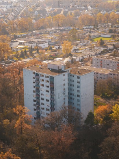 Large apartment block surrounded by autumn trees from above in an urban area, MÃ¼hlacker, Enzkreis, Germany