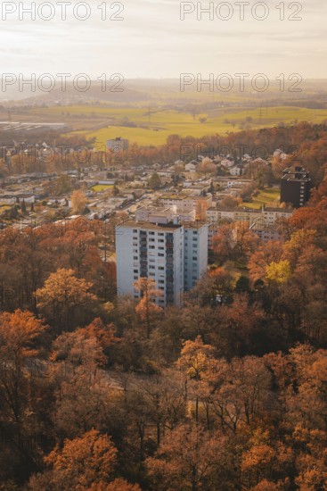 Block of flats surrounded by autumnal forest and fields close to the city in soft light, MÃ¼hlacker, Enzkreis, Germany