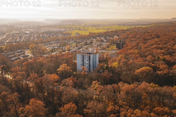 Residential area in the middle of a thick autumn forest with a tall building in the foreground, MÃ¼hlacker, Enzkreis, Germany