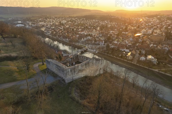 Medieval castle on a river surrounded by a town at sunset, MÃ¼hlacker, Enzkreis, Germany