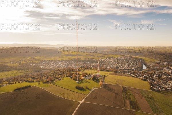 A radio tower stands in the middle of a vast, autumnal landscape next to a village, MÃ¼hlacker, Enzkreis, Germany