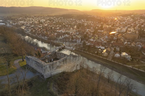 Medieval ruin on a river, with illuminated cityscape at dusk, MÃ¼hlacker, Enzkreis, Germany