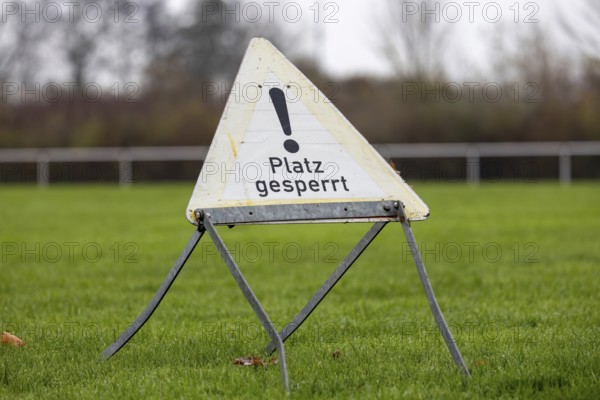 Sign with the inscription PLACE BLOCKED on a sports field (symbol image)