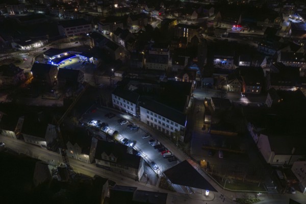 Nighttime view of city roads with parked cars and illuminated buildings, Nagold, Calw district, Germany