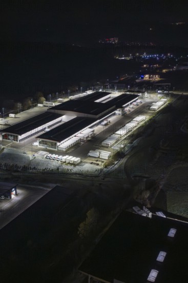 Night view of an industrial area with illuminated buildings and trucks, Nagold, Calw district, Germany