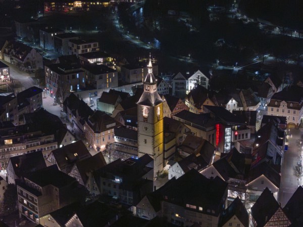 Night view of a town with a dominant, illuminated church tower in the middle, Nagold, Calw district, Germany