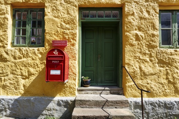 Post office, faÃ§ade detail, red mailbox with post horn and crown, green wooden door, yellow wall, ChristiansÃ¸, Christiansö, Ertholmene, Pea Islands, Bornholm, Baltic Sea, Denmark