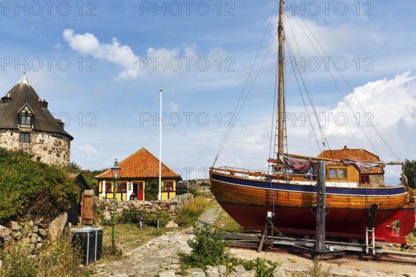Traditional wooden boat on slipway, small tower, Lille Tarn, round tower with museum, fortification, FrederiksÃ¸, Frederiksö, Ertholmene, Pea Islands, Bornholm, Denmark