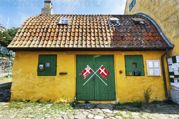 ChristiansÃ¸ Skole, smallest school in Denmark, curved tile roof, characteristic yellow and green, crossed Danish flags, Dannebrog, ChristiansÃ¸, Christiansö, Ertholmene, Pea Islands, Bornholm, Denmark