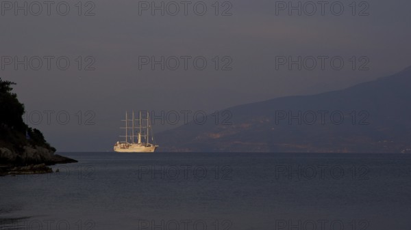 A large sailing ship sails in the calm sea in front of a dark mountain silhouette, Nauplion, Nafplion, Peloponnese, Greece