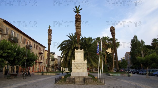 Old town of Nauplion, monument surrounded by palm trees and flags on a cozy town square, Nauplion, Nafplion, Peloponnese, Greece