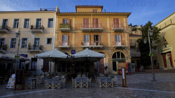 Old town of Nauplion, empty café area in front of historic faÃ§ade in sunny weather in a square, Nauplion, Nafplion, Peloponnese, Greece
