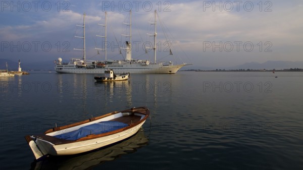 Nauplion harbour, sailing ship and small boat in harbour at sunset in calm water, Nauplion, Nafplion, Peloponnese, Greece