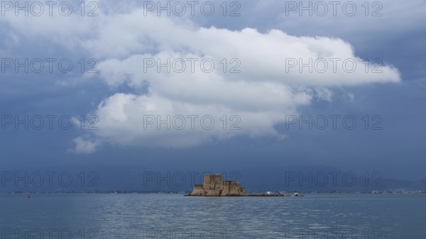 Bourtzi island fortress, small fortress on island under dramatically cloudy sky over the sea, Nauplion, Nafplion, Peloponnese, Greece