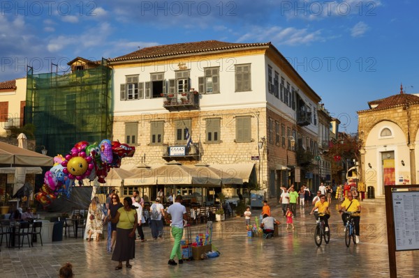 Old town of Nauplion, lively town square with cafés, people, bicycles and colorful balloons at sunset, Nauplion, Nafplion, Peloponnese, Greece