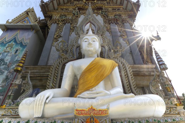 Buddha statue with tunic, Bhumispara mudra, Buddha Gautama at the moment of enlightenment, at the entrance to Wat Sitthawararam, Bangkok, Thailand