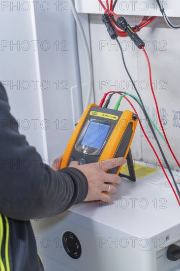 Technician uses measurement device to install solar system