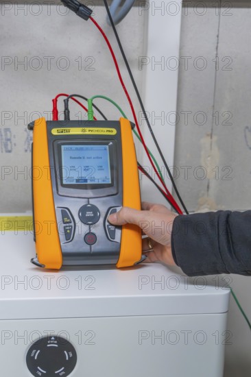 Person holding a measuring device device to check solar systems