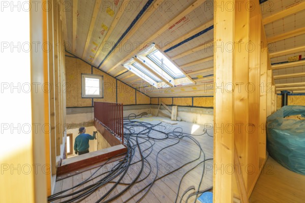 Top floor during renovation with cable harnesses and skylights that illuminate the room