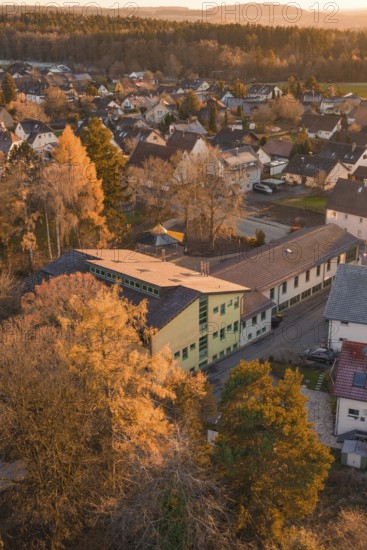 School building surrounded by autumn colors in a small village, nestled in nature, Althengstett, Calw district, Germany