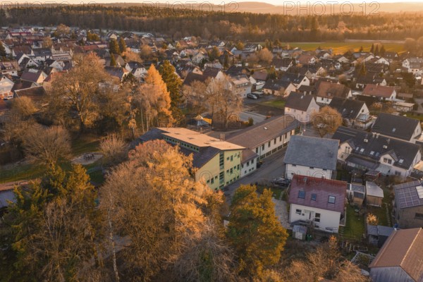 Rural area with houses and autumn trees in a warm evening atmosphere, Althengstett, Calw district, Germany