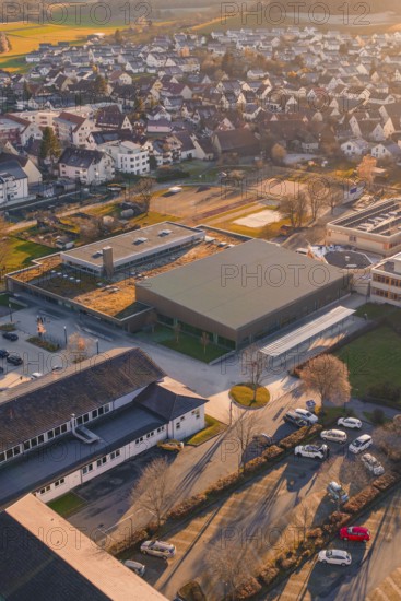 Aerial view of a village at sunset with a view of buildings and autumn colors, Althengstett sports center and swimming pool, Calw district, Germany