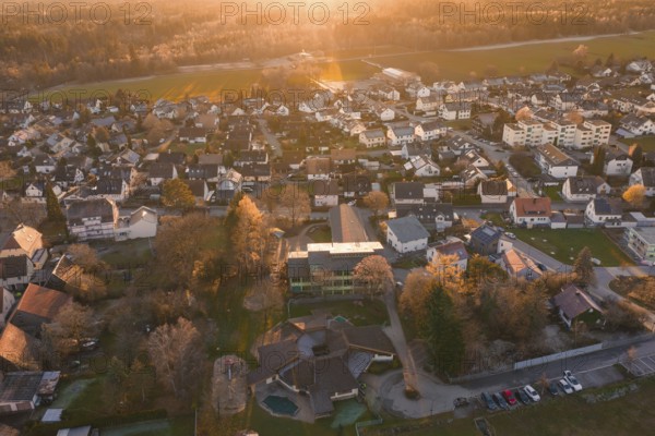 Large residential area in autumn light with many houses and nature seen from the air, Althengstett, Calw district, Germany