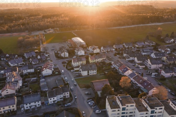 Suburb from the air with roads and cars in the evening sun, surrounded by nature, Althengstett, Calw district, Germany