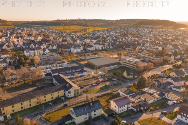 Aerial view of a settlement in warm evening light with hills and landscape in the background, Althengstett, Calw district, Germany