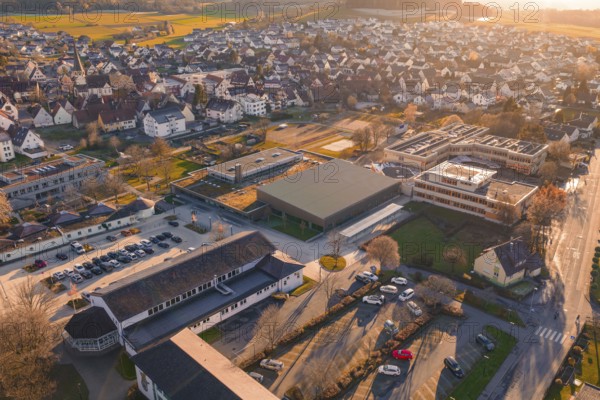 Village visible from above with sunset, roofs and surrounding landscape, Althengstett sports center and swimming pool, Calw district, Germany