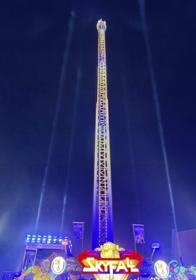 Colourfully illuminated Skyfal free fall tower at night at the All Saints Fair, Soest, North Rhine-Westphalia, Germany