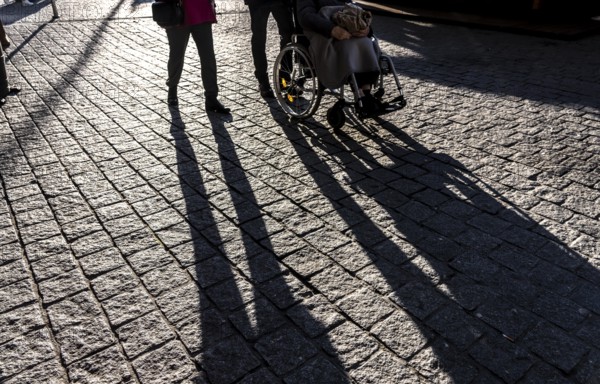 Shadows of people on the ground, low sun, winter, silhouettes, elderly person in wheelchair, Germany