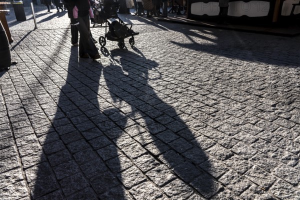 Shadows of people on the ground, low sun, winter, silhouettes, stroller, Germany