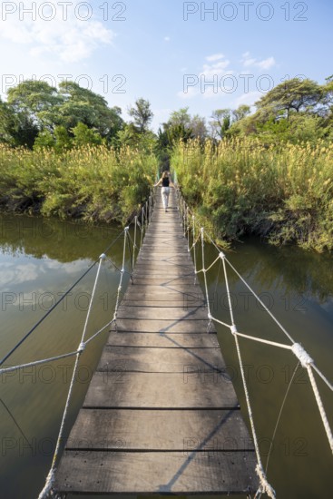Toruist on the Kavango River, suspension bridge at Camp Kwando, Zambezi region, Caprivi Strip, Namibia