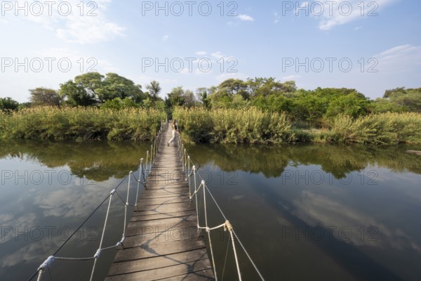 Toruist on the Kavango River, suspension bridge at Camp Kwando, Zambezi region, Caprivi Strip, Namibia