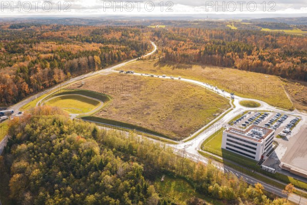 Industrial site with parking lot and adjacent forest in an autumn setting, new Lindenrain industrial park, Calw, Black Forest, Germany