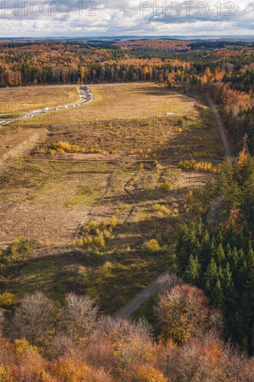 Autumn scene from the air with open landscape, colorful forest and fields, new Lindenrain industrial park, Calw, Black Forest, Germany