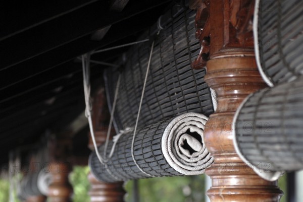 Close-up view of rolled bamboo blinds and artfully turned wooden posts, Heritage Hotel Privacy, Vembanad Lake, Kerala, India