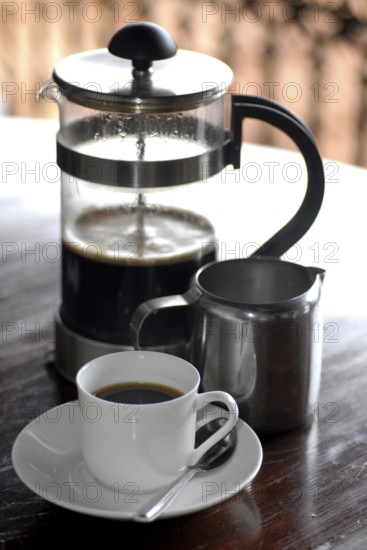 French coffee press next to a cup of coffee and a milk jug on a table, Serenity boutique hotel, Malabar Escapes, Kerala, India